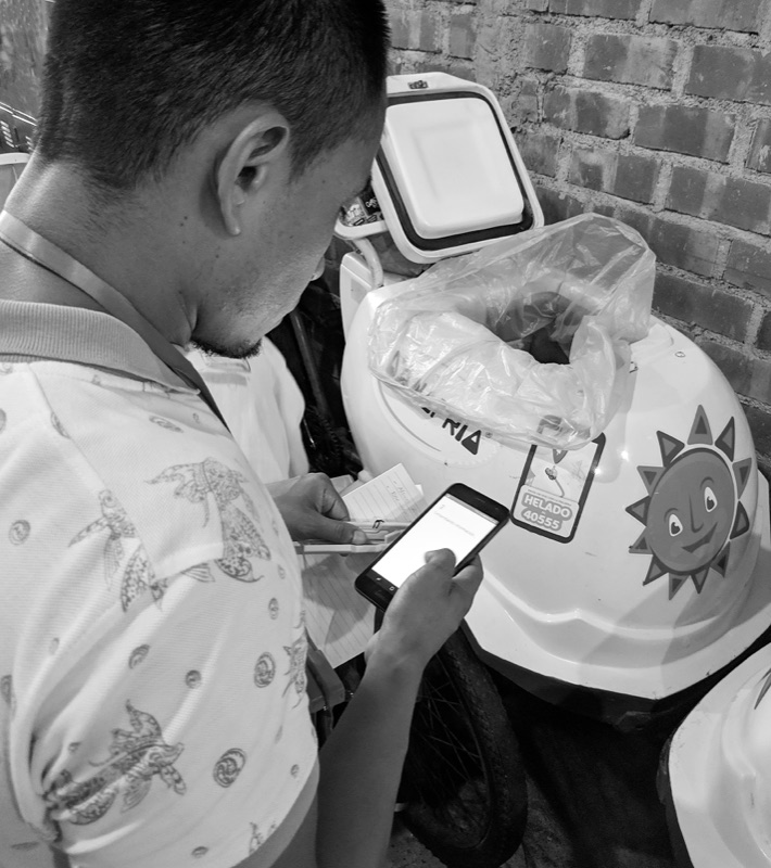 Vendor checking his phone at the end of the day