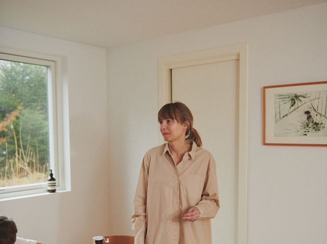 A parent standing in a living room during an interview